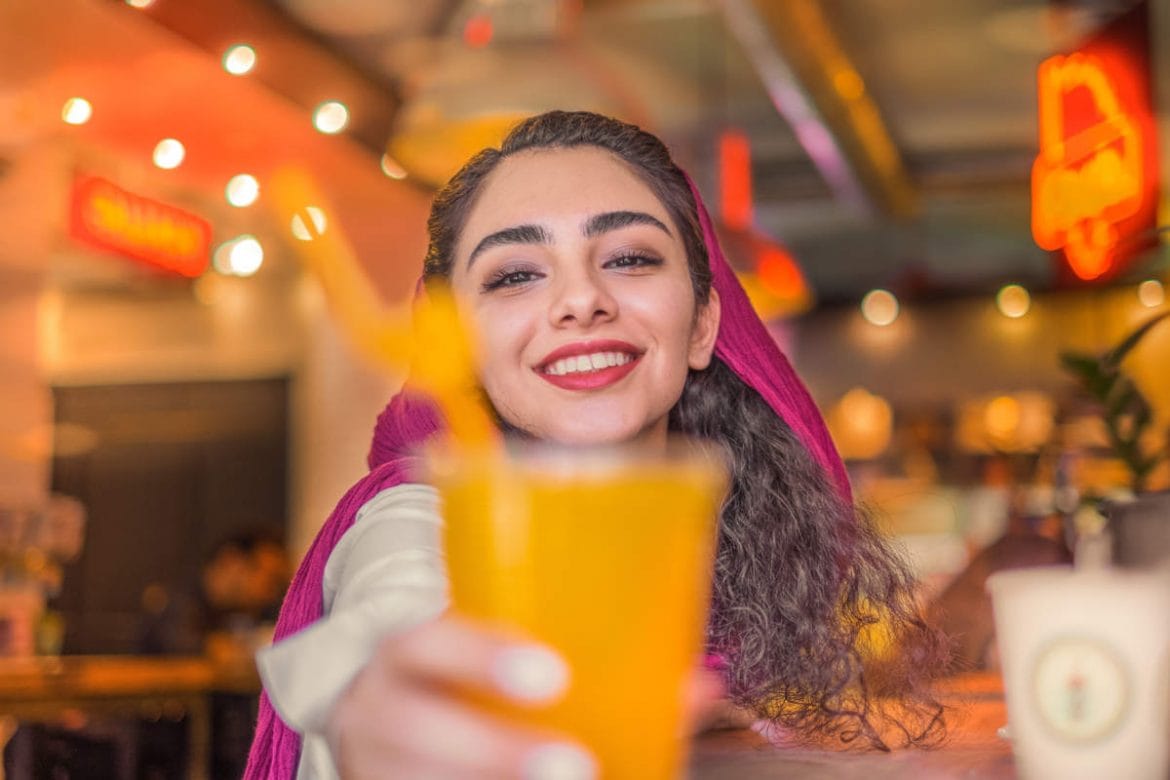 Chica bebiendo un zumo de naranja