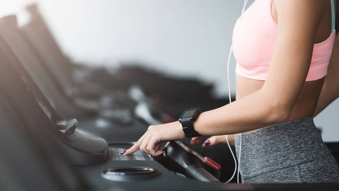 Mujer en el gimnasio con una pulsera de actividad
